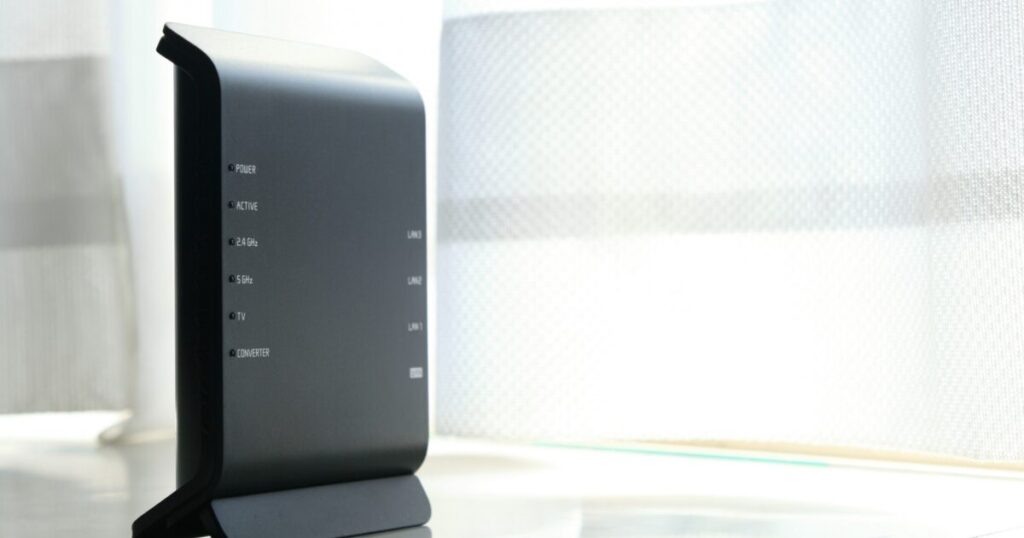 窓際に置かれた黒いWi-Fiルーター