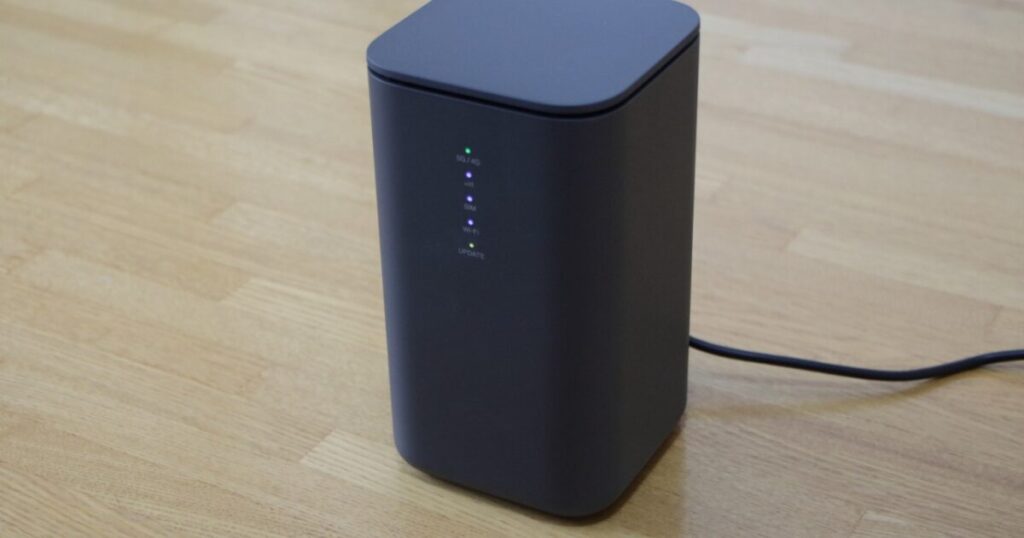 木製の床に置かれた黒いWi-Fiルーター