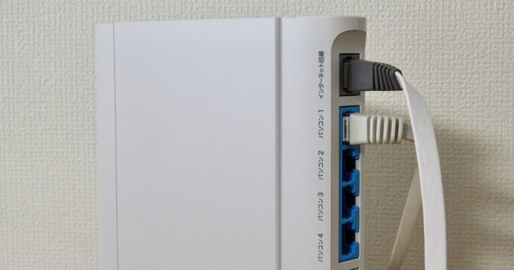 LANケーブルが接続された白い無線ルーターの背面